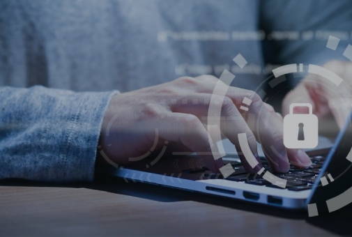 Hands typing on a laptop with a glowing lock and security rings, symbolizing cybersecurity.